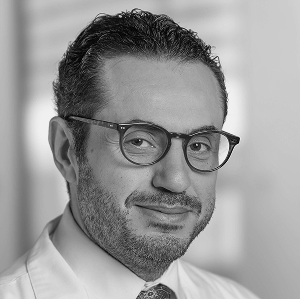 Headshot of Mazen Noureddin, MD, MHSc a man wearing glasses with a close cut beard and mustache and short hair smiling.